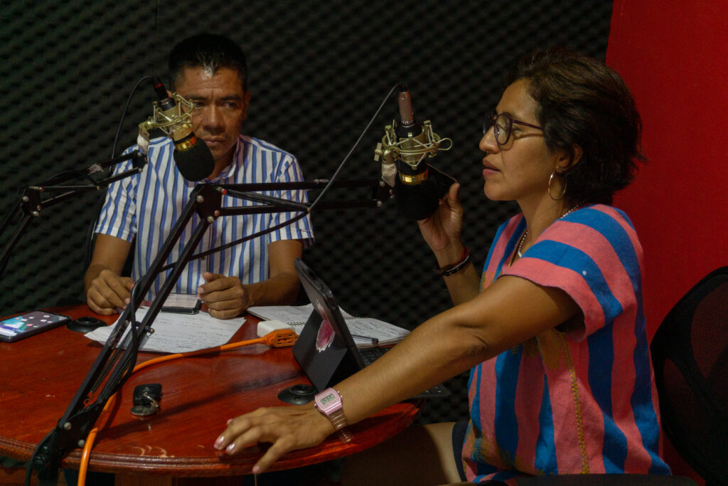 Two people in an interview studio sitting at microphones
